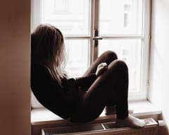 Person sitting alone by a window