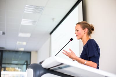A speaker on stage in front of an audience