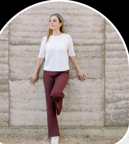 Dr. Azadeh Weber leaning against a stone wall